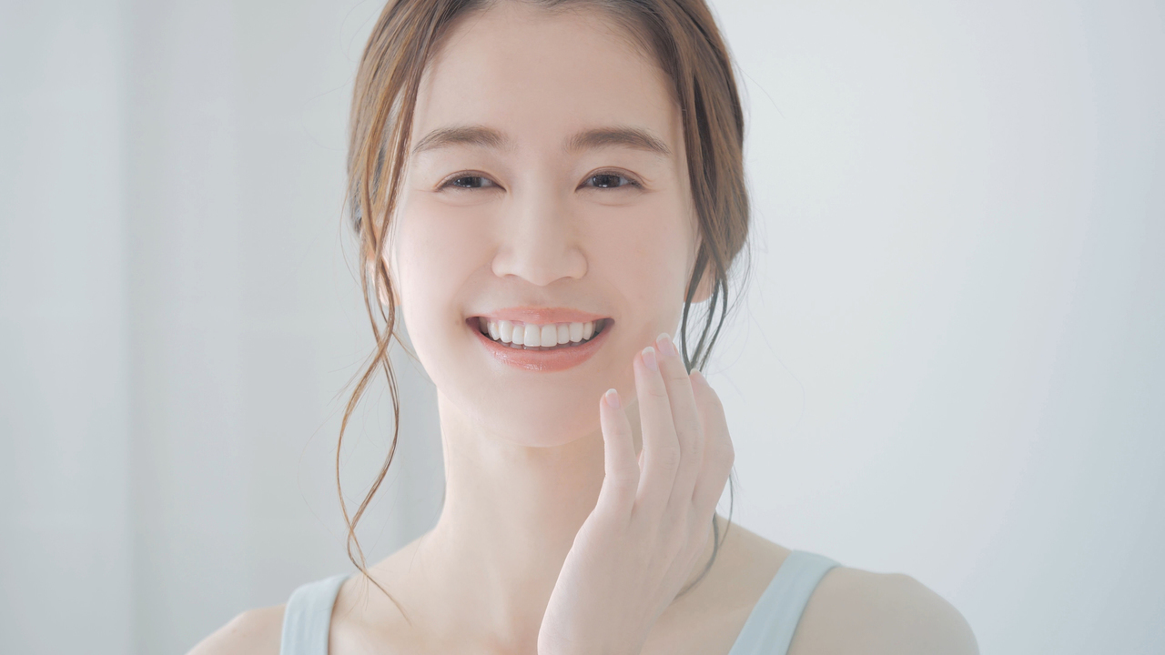 自分自身の歯がきれいに並んで嬉しそうな女性のイメージ写真