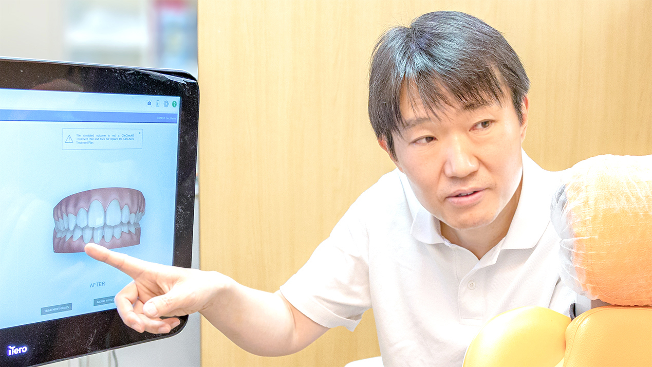 検査画像を見せながら患者に説明を行っている院長の写真